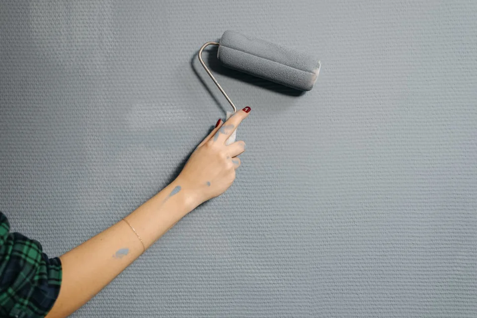 Rouleau de peinture passé sur un mur gris